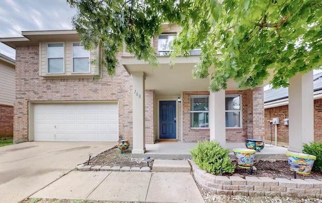 view of front of house with an attached garage, covered porch, brick siding, and concrete driveway