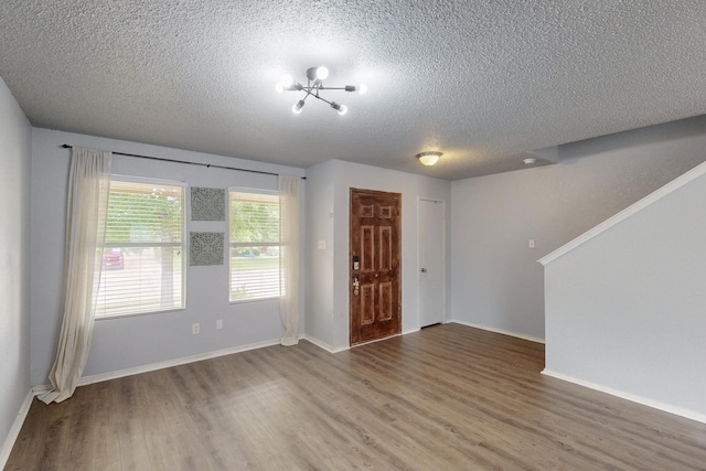 entryway with baseboards, a textured ceiling, and wood finished floors
