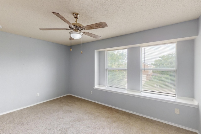 empty room with carpet floors, a textured ceiling, baseboards, and ceiling fan