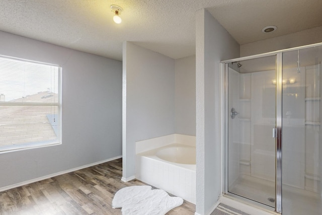 full bath featuring a garden tub, baseboards, a shower stall, and wood finished floors