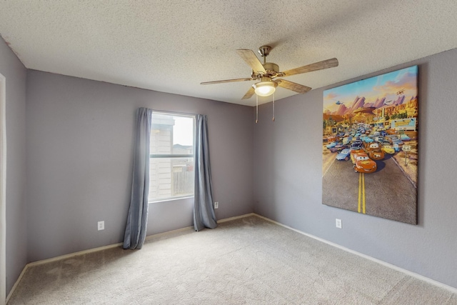 unfurnished room with baseboards, light carpet, a ceiling fan, and a textured ceiling