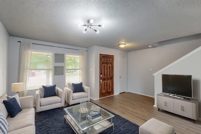 living area featuring baseboards, a textured ceiling, and wood finished floors