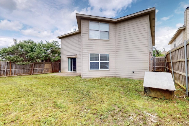 rear view of house with a fenced backyard, a patio, and a yard