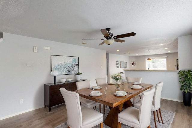 dining space with visible vents, baseboards, ceiling fan, and wood finished floors
