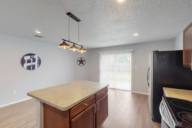 kitchen with a textured ceiling, visible vents, and light wood-type flooring