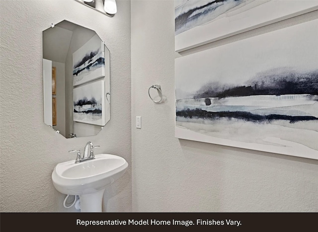bathroom with a textured wall and a sink