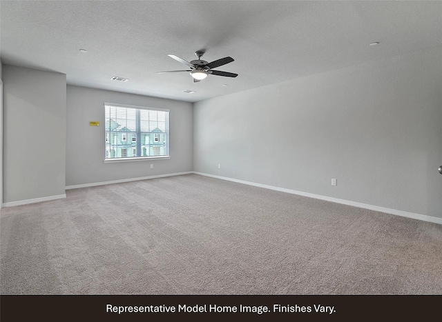 spare room featuring visible vents, baseboards, ceiling fan, and carpet floors
