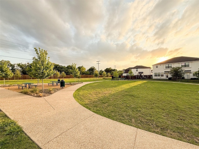 view of community with a lawn and fence