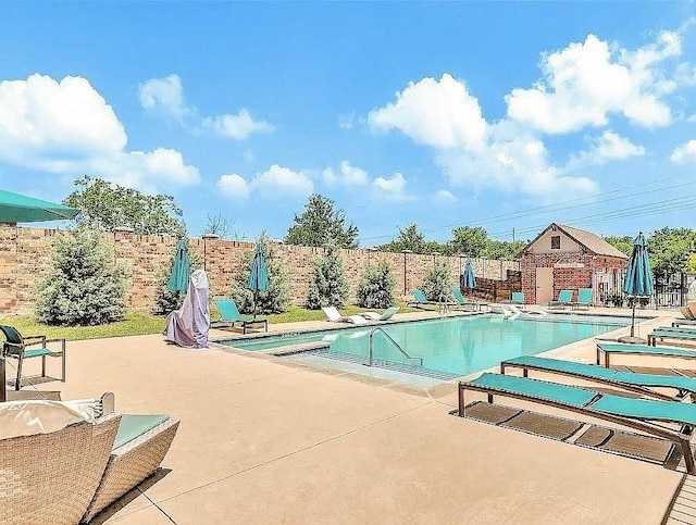 pool featuring fence and a patio area