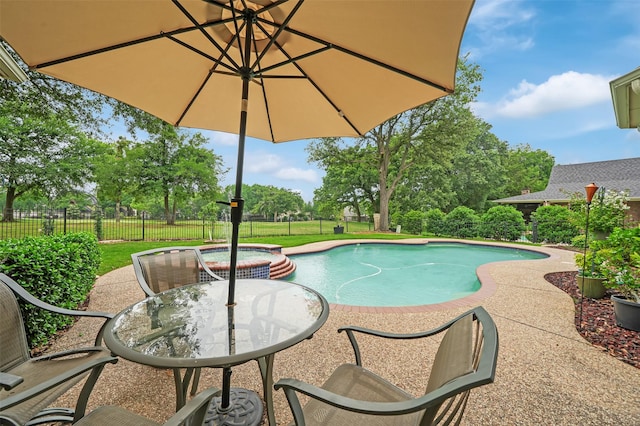 view of pool featuring fence, a pool with connected hot tub, and a patio
