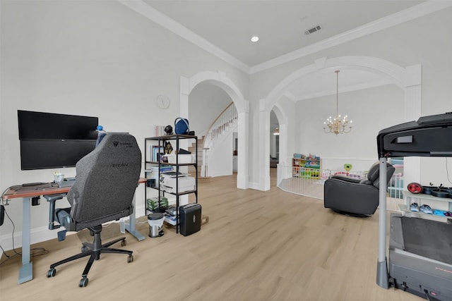 office space featuring ornamental molding, wood finished floors, arched walkways, a chandelier, and baseboards