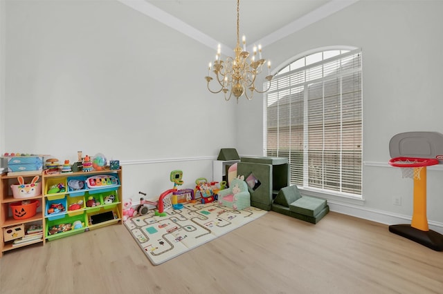 playroom featuring wood finished floors, a chandelier, and baseboards