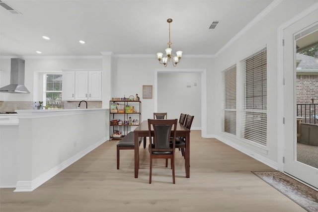 dining area with light wood-style floors, a chandelier, plenty of natural light, crown molding, and recessed lighting