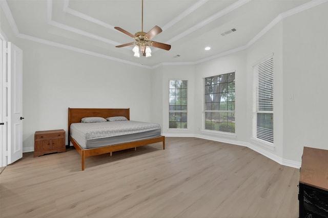 bedroom with wood finished floors, a tray ceiling, ornamental molding, ceiling fan, and recessed lighting