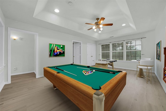 rec room with a raised ceiling, light wood-style flooring, a ceiling fan, recessed lighting, and baseboards
