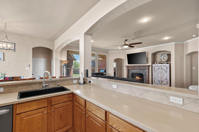 1185 Shores Blvd, Rockwall, TX 75087 - kitchen with a warm lit fireplace, a sink, ceiling fan with notable chandelier, open floor plan, and stainless steel dishwasher