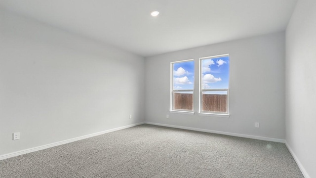 unfurnished room with light colored carpet, recessed lighting, and baseboards