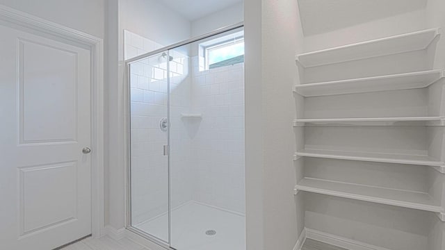bathroom featuring baseboards and a stall shower