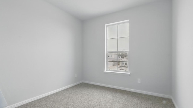 empty room featuring baseboards and light colored carpet