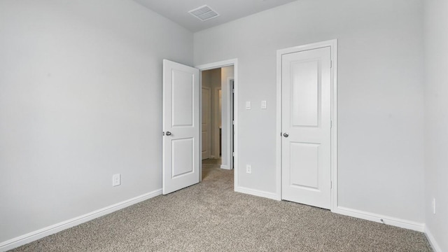 unfurnished bedroom with baseboards, visible vents, and light colored carpet