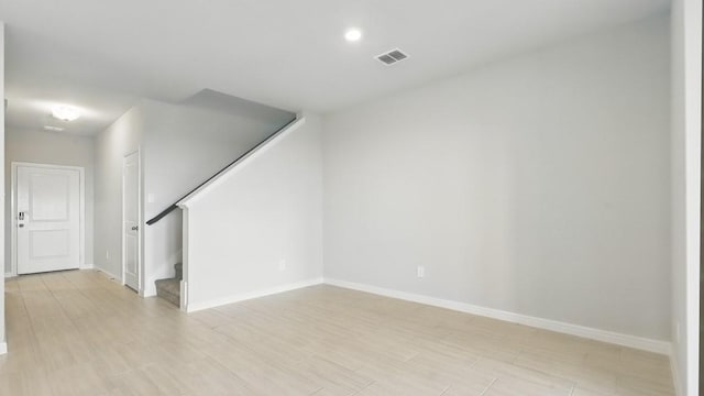 interior space featuring stairs, baseboards, visible vents, and light wood-type flooring