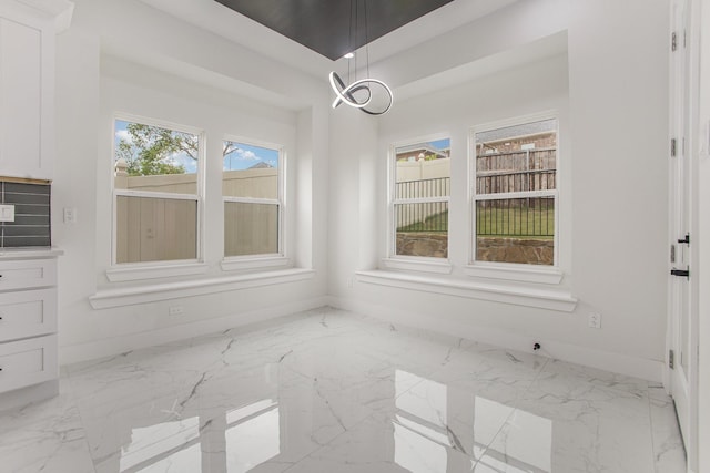 unfurnished dining area with baseboards and marble finish floor