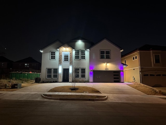 traditional-style home featuring concrete driveway, an attached garage, cooling unit, and stucco siding