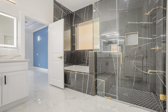 full bathroom featuring baseboards, vanity, marble finish floor, a marble finish shower, and a tub to relax in