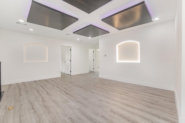 empty room featuring coffered ceiling, recessed lighting, wood finished floors, and visible vents