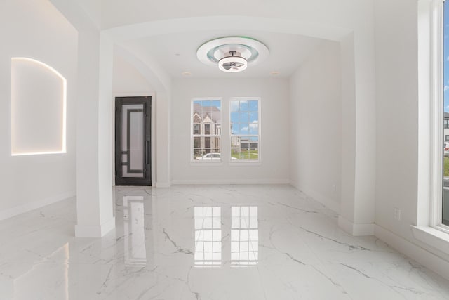 empty room with baseboards and marble finish floor
