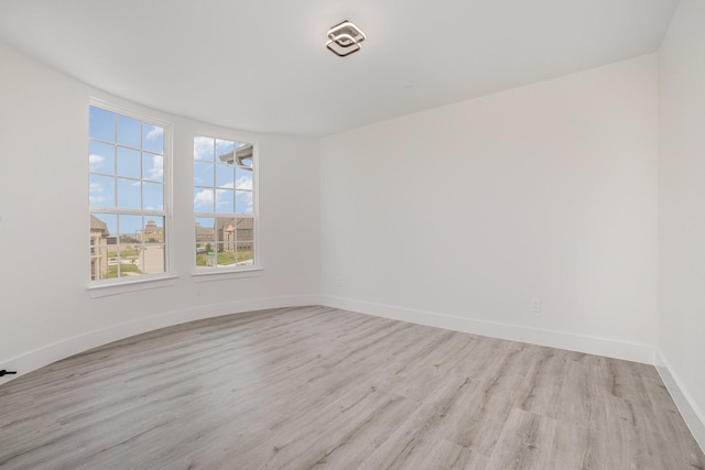 unfurnished room featuring baseboards and light wood finished floors