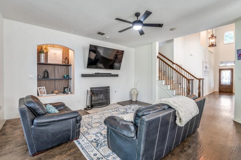 3301 Ski Lift Ct, Mckinney, TX 75070 - living area featuring stairs, visible vents, dark wood finished floors, a ceiling fan, and a fireplace with flush hearth