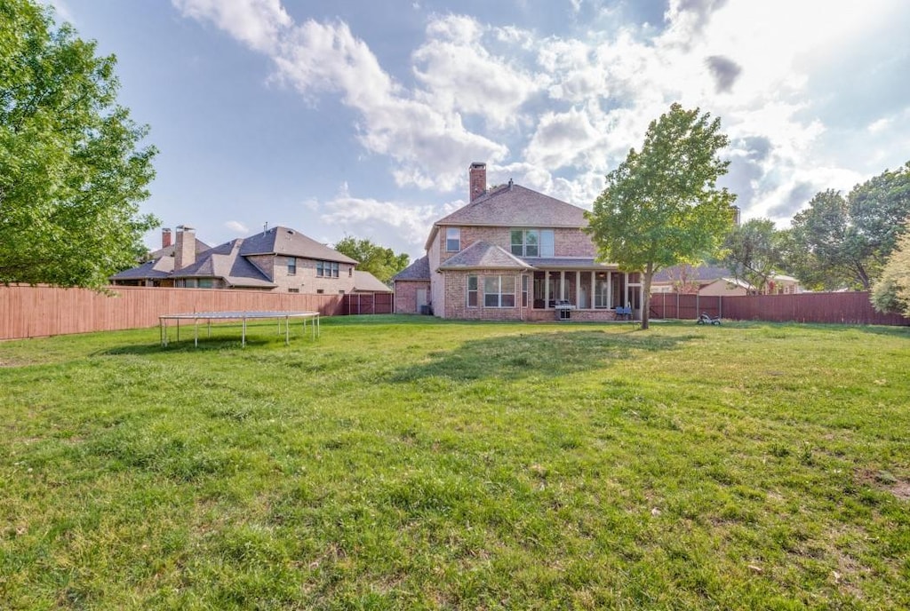 3301 Ski Lift Ct, Mckinney, TX 75070 - view of yard featuring a fenced backyard and a trampoline