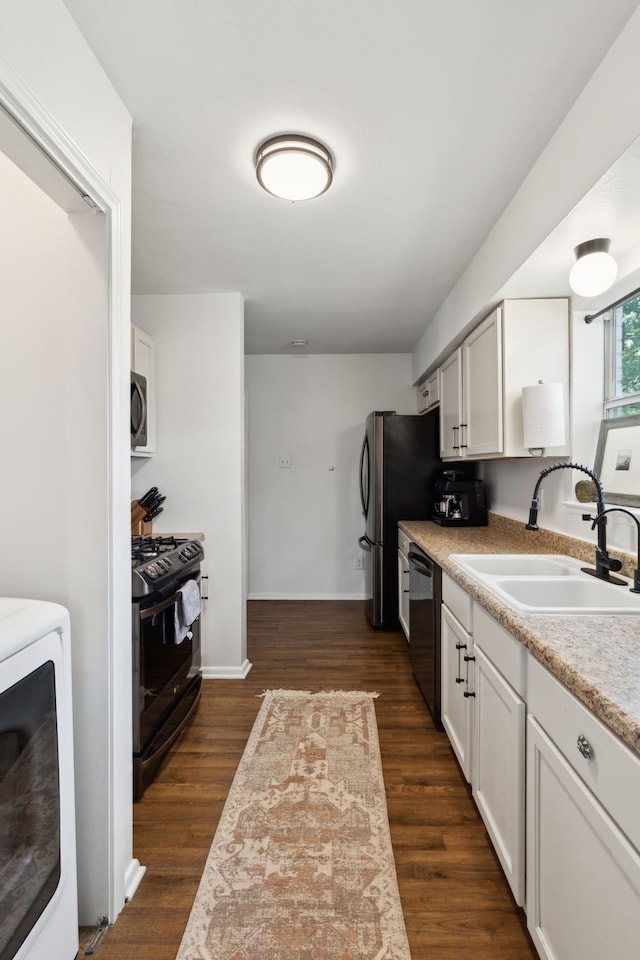 3049 Rotan Ln, Dallas, TX 75229 - kitchen featuring appliances with stainless steel finishes, a sink, light countertops, washer / dryer, and dark wood-type flooring