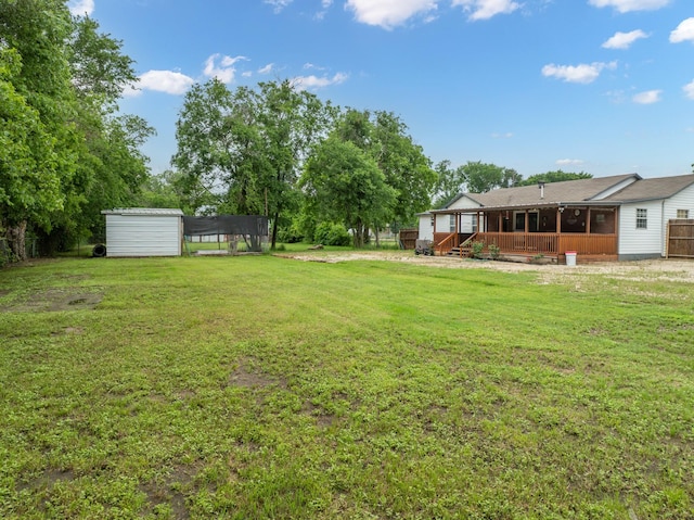 view of yard with a storage shed, a sunroom, a deck, an outbuilding, and a detached carport