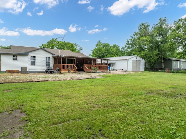 rear view of house featuring a lawn and a deck