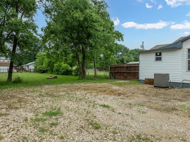 view of yard with fence and central AC