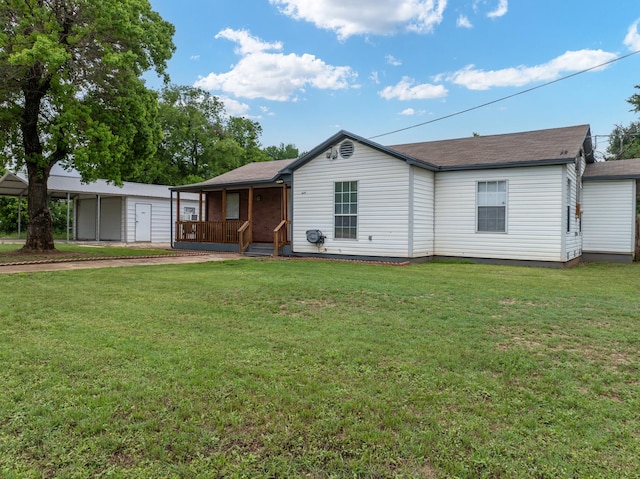 rear view of house with roof with shingles, a yard, and a porch