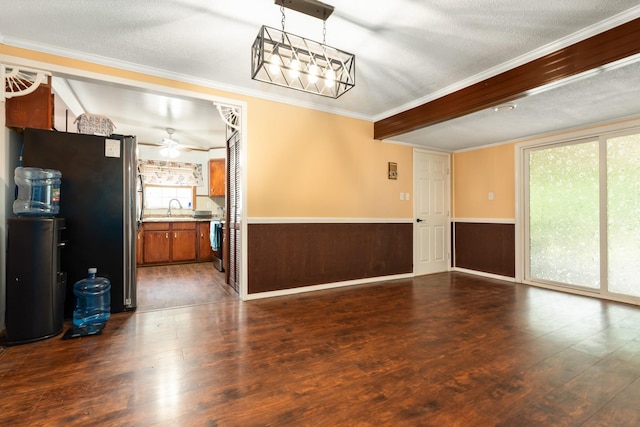 interior space featuring a ceiling fan, a sink, a wainscoted wall, dark wood-style floors, and ornamental molding
