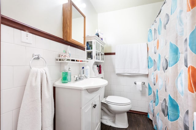 full bath featuring a shower with curtain, tile walls, wood finished floors, vanity, and toilet