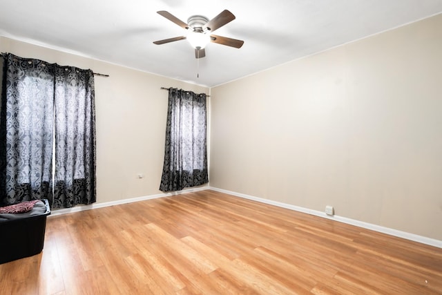 spare room with a ceiling fan, baseboards, and light wood-type flooring