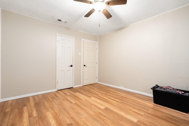empty room featuring visible vents, light wood-style flooring, ceiling fan, and baseboards