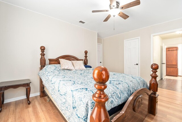 bedroom with visible vents, a ceiling fan, light wood-style flooring, and baseboards