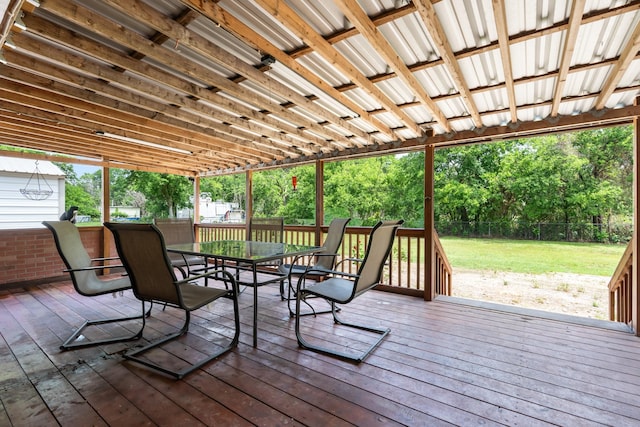deck with outdoor dining area, a fenced backyard, and a yard