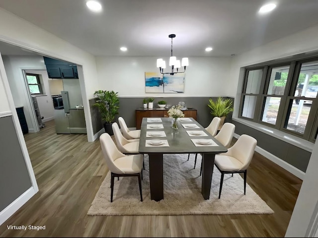dining room with a chandelier, recessed lighting, wood finished floors, and baseboards