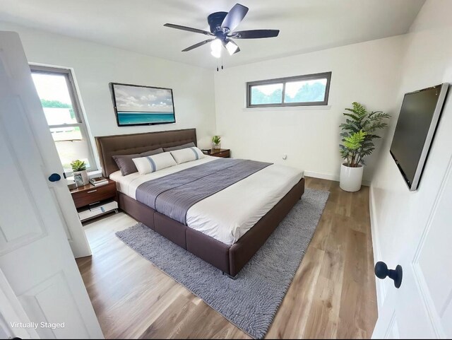 bedroom with wood finished floors, ceiling fan, and baseboards