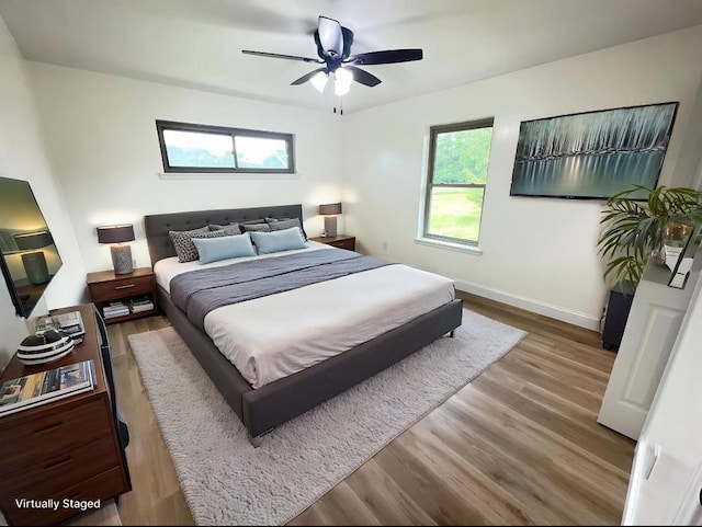 bedroom featuring wood finished floors, baseboards, and ceiling fan