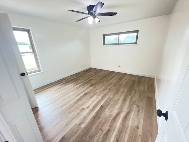 empty room featuring wood finished floors, ceiling fan, and baseboards