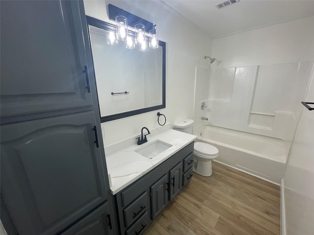 bathroom featuring wood finished floors, toilet, bathtub / shower combination, and vanity