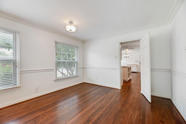 spare room with crown molding, baseboards, dark wood finished floors, and visible vents